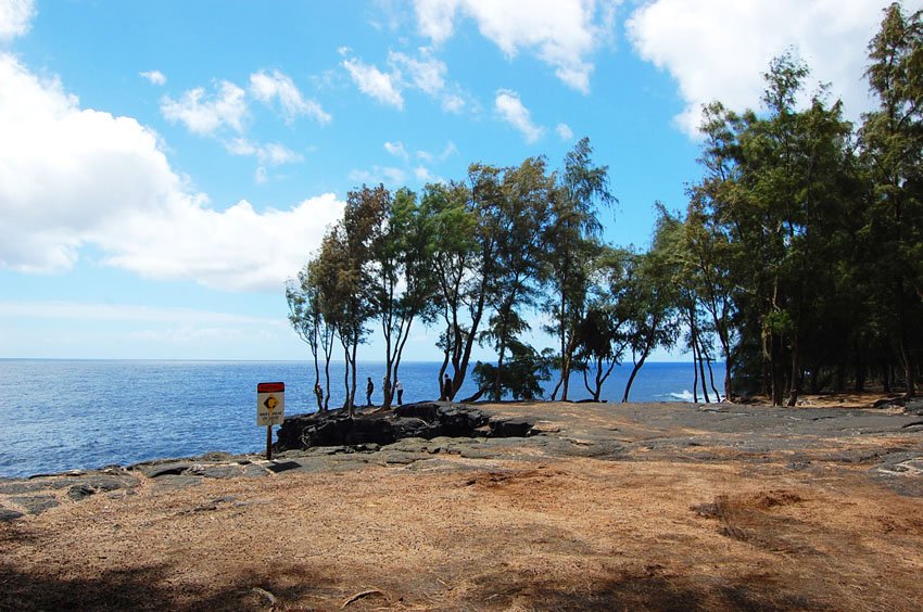 Waves break on ledge warning sign