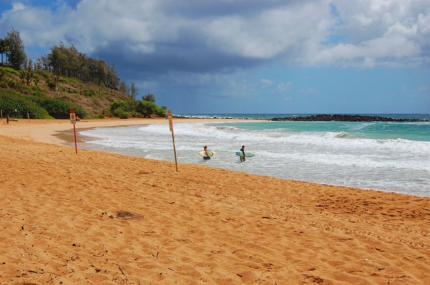 Surfers heading into the ocean