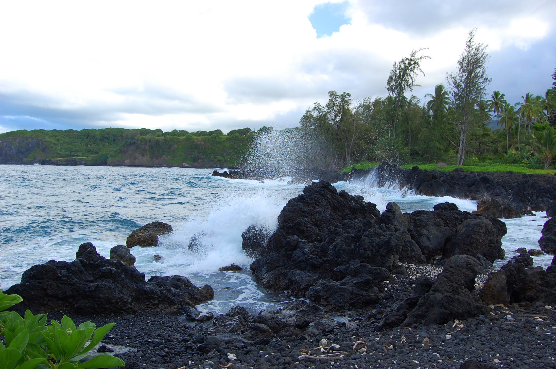 Waves crash against lava rocks